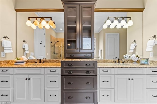 bathroom with crown molding, a stall shower, and a sink