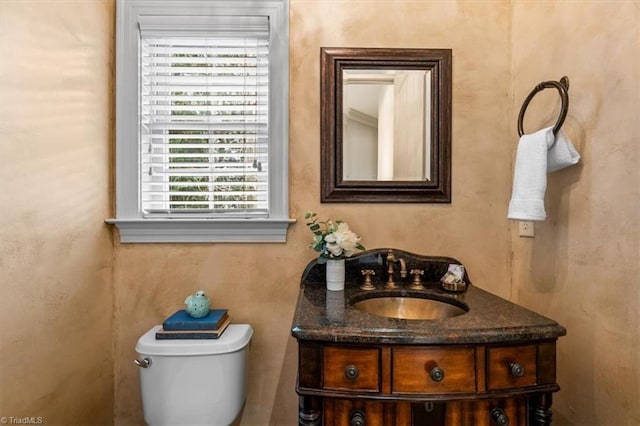 half bathroom with vanity and toilet