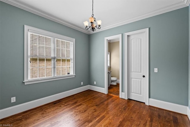 unfurnished room with baseboards, an inviting chandelier, dark wood finished floors, and ornamental molding