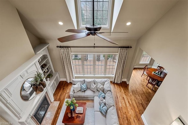 living area featuring recessed lighting, ceiling fan, baseboards, and wood finished floors