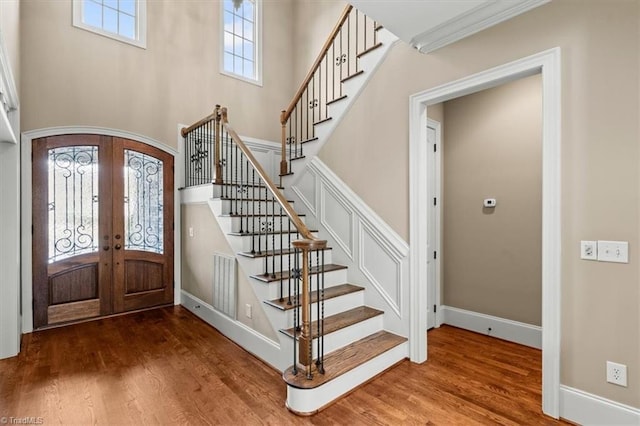 foyer with french doors, wood finished floors, and stairs