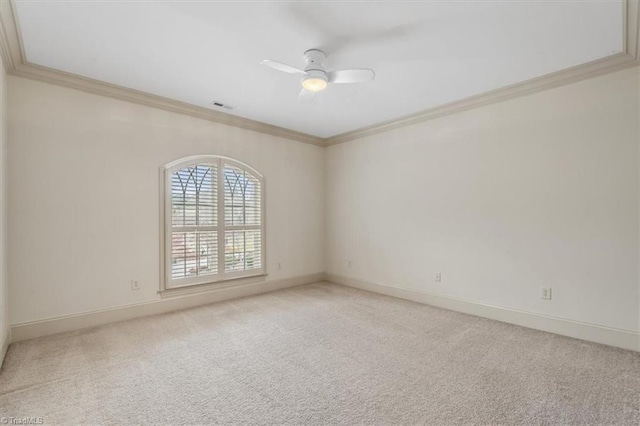 spare room with visible vents, light colored carpet, crown molding, and a ceiling fan