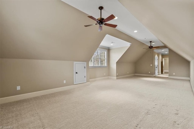 additional living space featuring a ceiling fan, lofted ceiling, light colored carpet, and baseboards