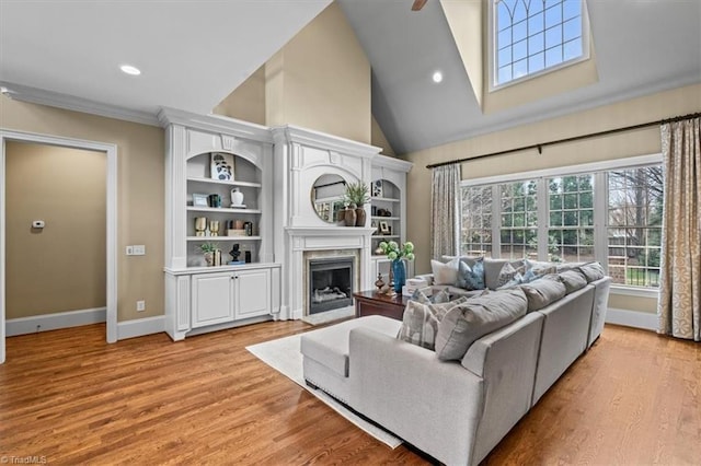 living room with high vaulted ceiling, light wood-style flooring, recessed lighting, a fireplace, and baseboards