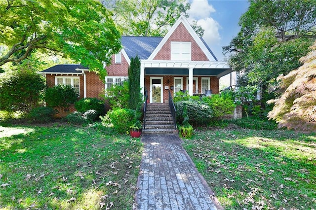 tudor house featuring a front lawn and a porch