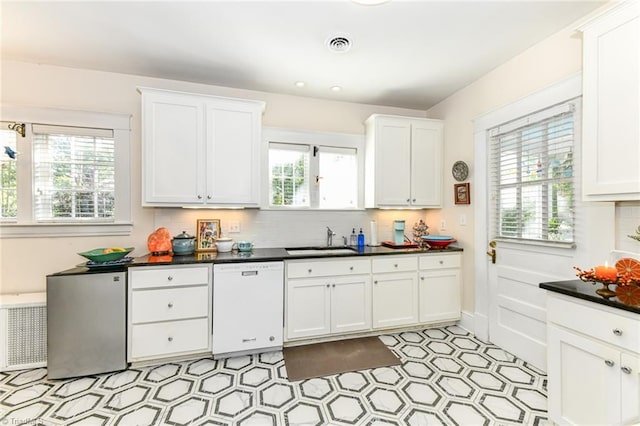 kitchen featuring white cabinets, white dishwasher, and plenty of natural light