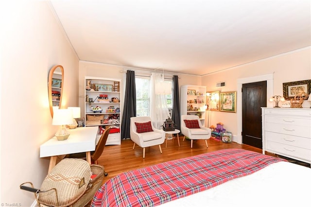 living area with wood-type flooring and ornamental molding