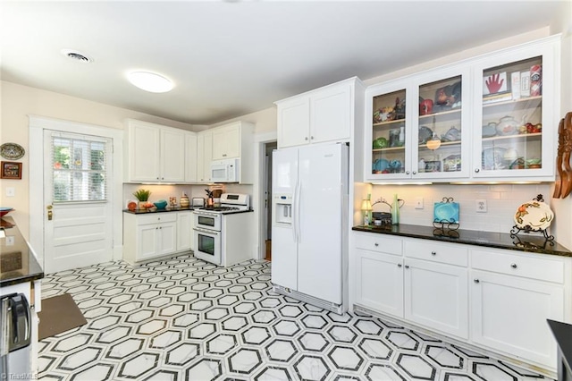 kitchen with white cabinets, tasteful backsplash, and white appliances