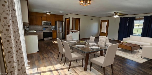 dining room featuring hardwood / wood-style floors, ornamental molding, sink, and ceiling fan