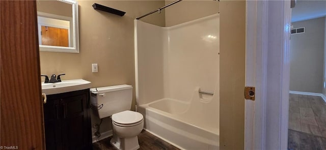 full bathroom featuring hardwood / wood-style flooring, vanity, washtub / shower combination, and toilet