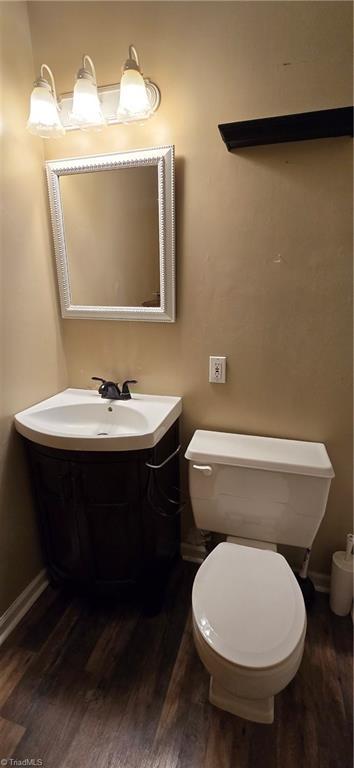 bathroom with hardwood / wood-style flooring, vanity, and toilet