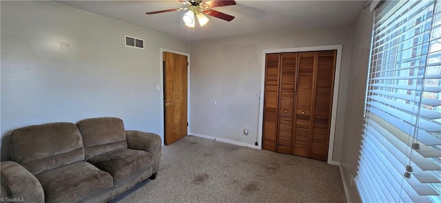 carpeted living room with ceiling fan