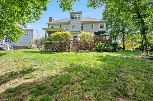rear view of property with stairway, a deck, a chimney, and a yard