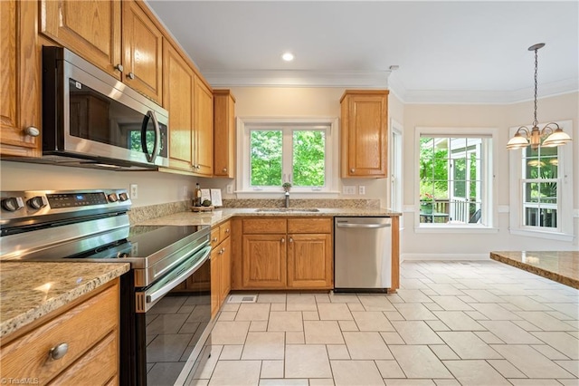 kitchen featuring stainless steel appliances, a sink, ornamental molding, light stone countertops, and a chandelier