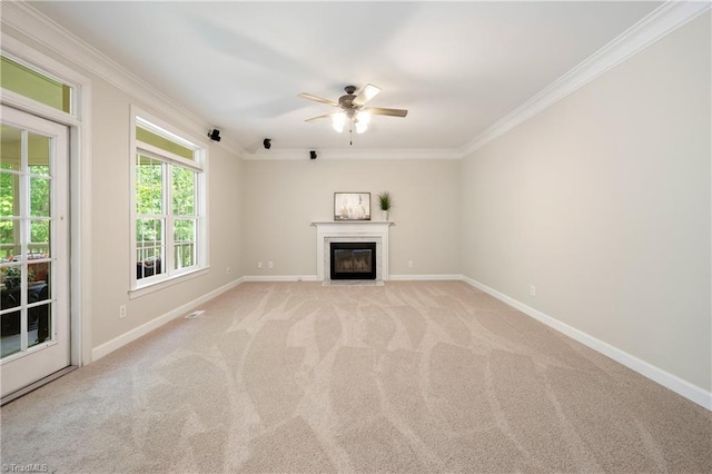 unfurnished living room featuring crown molding, a ceiling fan, baseboards, light colored carpet, and a fireplace with flush hearth