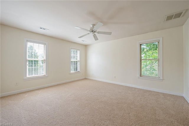 empty room featuring baseboards, light colored carpet, and ceiling fan