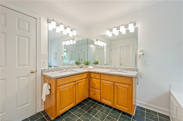 full bathroom featuring tile patterned flooring, double vanity, a stall shower, and baseboards
