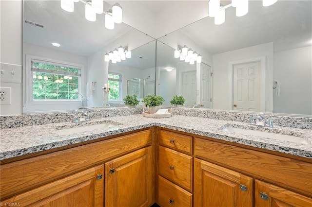 bathroom with double vanity and a shower stall