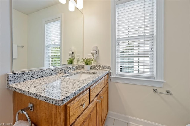 bathroom featuring healthy amount of natural light, vanity, and baseboards