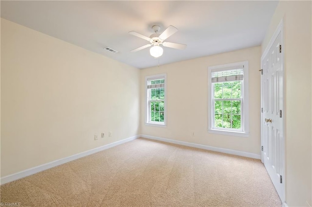 spare room featuring baseboards, ceiling fan, and light colored carpet