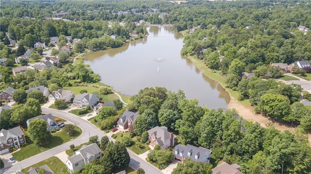 aerial overview of property's location with a nearby body of water, nearby suburban area, and a heavily wooded area