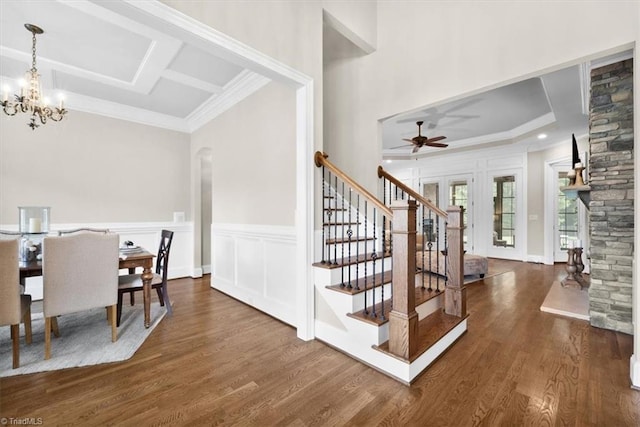 dining space with ornamental molding, ceiling fan with notable chandelier, and dark hardwood / wood-style flooring