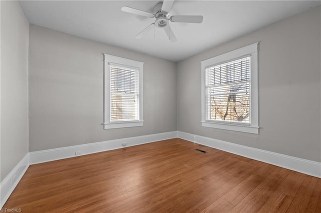 empty room featuring hardwood / wood-style floors, a healthy amount of sunlight, and ceiling fan