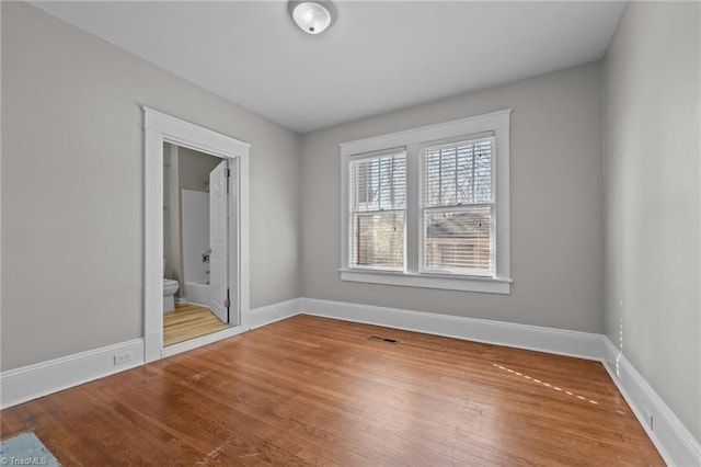 unfurnished room with hardwood / wood-style flooring