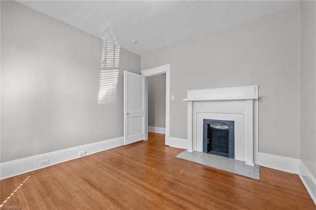 unfurnished living room with hardwood / wood-style floors and vaulted ceiling