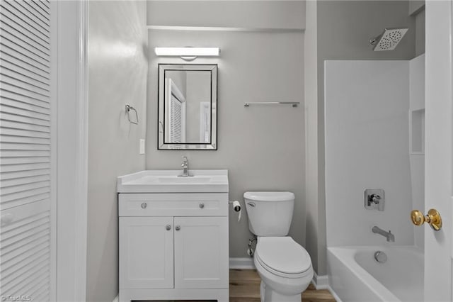 full bathroom featuring vanity, wood-type flooring, washtub / shower combination, and toilet