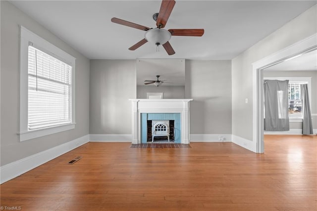 unfurnished living room featuring a healthy amount of sunlight and hardwood / wood-style floors