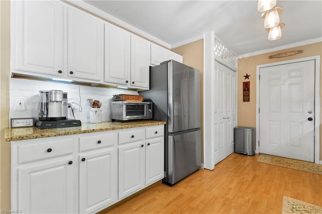 1044 Riverwood Rd, Lexington, NC 27292 - kitchen with freestanding refrigerator, white cabinets, crown molding, light wood-type flooring, and decorative backsplash