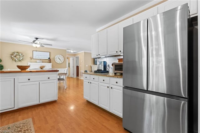 1044 Riverwood Rd, Lexington, NC 27292 - kitchen with freestanding refrigerator, white cabinets, light wood-style floors, a ceiling fan, and ornamental molding