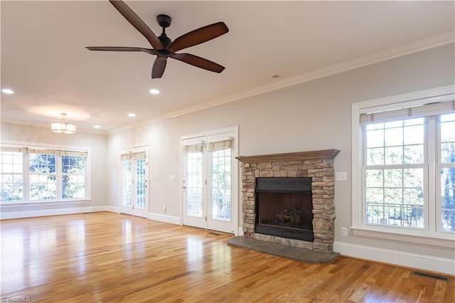 unfurnished living room featuring crown molding, ceiling fan, a fireplace, and light hardwood / wood-style floors