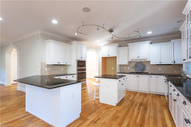 kitchen with a kitchen bar, white cabinets, and appliances with stainless steel finishes