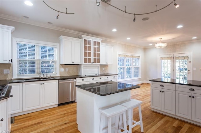 kitchen with stainless steel dishwasher, light hardwood / wood-style floors, white cabinets, and a center island