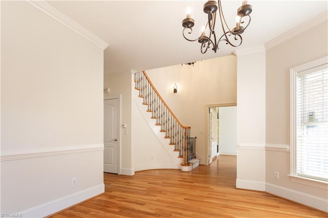 interior space featuring ornamental molding, an inviting chandelier, and light hardwood / wood-style floors