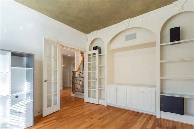 spare room with built in shelves, wood-type flooring, and french doors