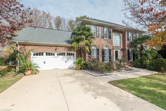 colonial inspired home with a front lawn and a garage