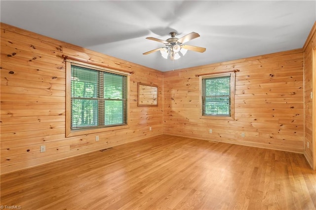 7849 Circle L Trl, Rougemont, NC 27572 - unfurnished room featuring healthy amount of natural light, ceiling fan, wood walls, and light wood-style floors