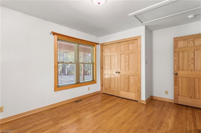 7849 Circle L Trl, Rougemont, NC 27572 - unfurnished bedroom with light wood-style flooring, a closet, and attic access