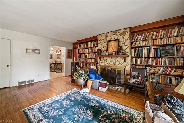 1204 Hobbs Rd, Greensboro, NC 27410 - sitting room featuring wood finished floors, a stone fireplace, and built in features