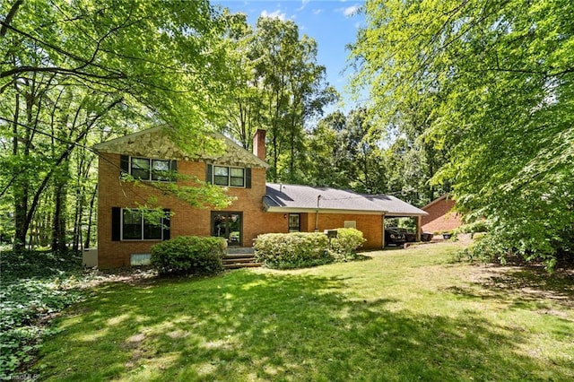 1204 Hobbs Rd, Greensboro, NC 27410 - rear view of property featuring a yard, a chimney, and brick siding