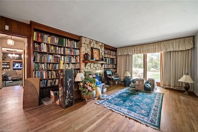 1204 Hobbs Rd, Greensboro, NC 27410 - sitting room featuring a fireplace, wood finished floors, built in shelves, and wood walls