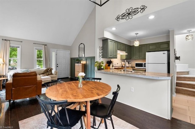 dining space with dark wood-style floors, baseboards, high vaulted ceiling, and recessed lighting
