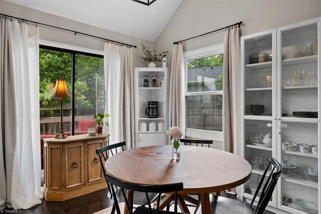 dining room with lofted ceiling and dark wood finished floors