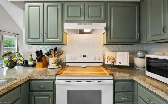 kitchen with under cabinet range hood, green cabinetry, tile countertops, and white appliances