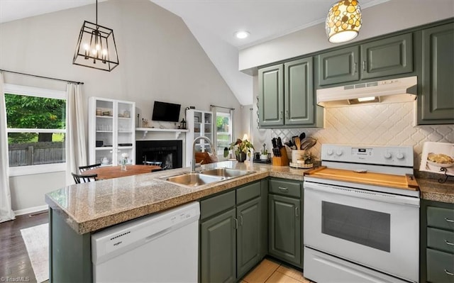 kitchen with under cabinet range hood, white appliances, a sink, a peninsula, and green cabinetry