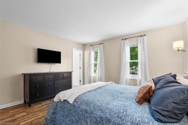 bedroom with baseboards and wood finished floors