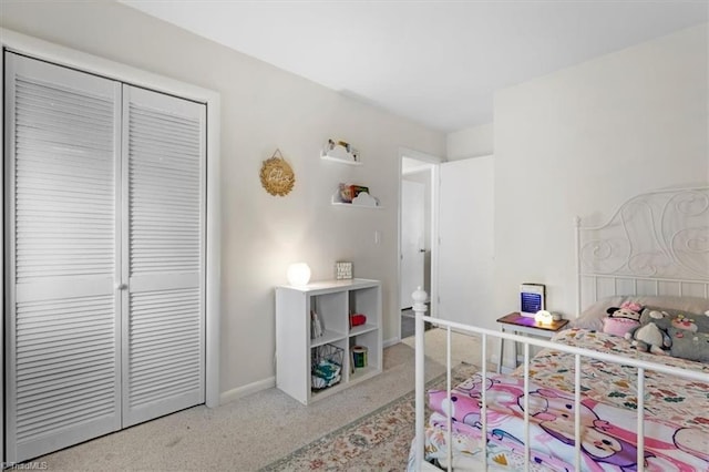 bedroom featuring a closet, baseboards, and carpet floors